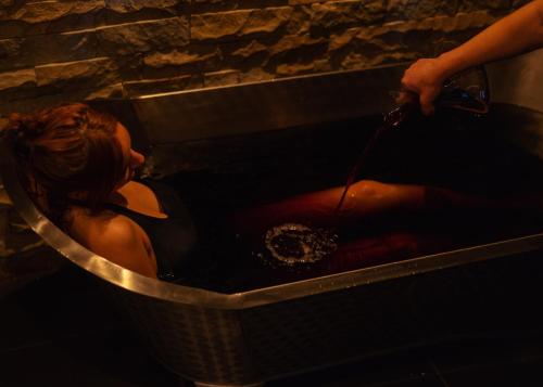 Schuchmann Wines Château,Villas & SPA في تيلافي: امرأة تجلس في حوض الاستحمام