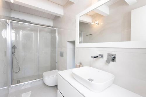 a white bathroom with a sink and a shower at Panoramic Villa #1 in Hanioti