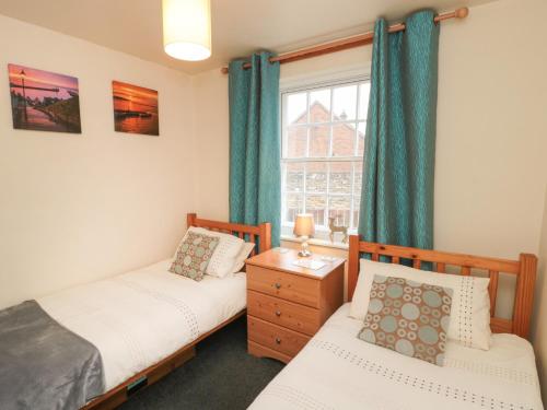 a twin bedroom with two beds and a window at Apartment 1 Sneaton Hall in Sneaton