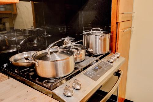 three pots and pans on a stove in a kitchen at Honey Spot in Springfield