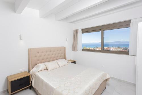 a white bedroom with a bed and a window at Panoramic Villa #1 in Hanioti