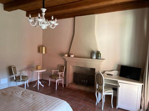 1 dormitorio con chimenea, 1 cama y sillas en Agriturismo Il Torriglione, en La Morra