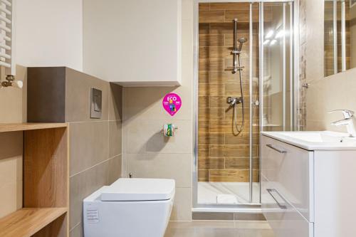 uma casa de banho com um chuveiro, um WC e um lavatório. em VacationClub – Górna Resorts Apartament 83 em Szklarska Poręba