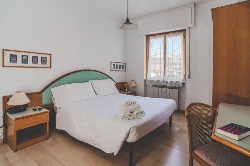 a bedroom with a large white bed and a table at Hotel Bacco Rooms and Breakfast in Pietra Ligure