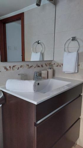 a bathroom with a white sink and a mirror at La Casona de Teo in San Juan de la Arena