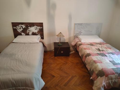 a room with two beds and a table with a lamp at Casa - house Xavier una casa famigliare , dame entra solo Chi a un bel cuore , non'e il l'intero alloggio solo stanze e bagno in Turin