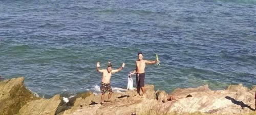 deux hommes debout sur les rochers près de l'océan dans l'établissement Daldagons View Deck, 