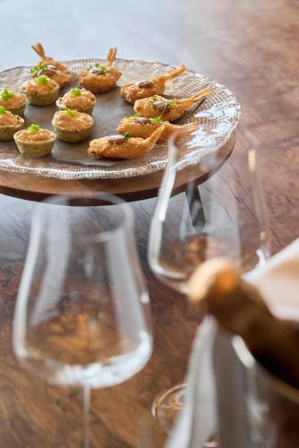 a table with a plate of food and two wine glasses at Luxury Chalet Vilaiet in Ortisei