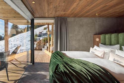 1 dormitorio con 1 cama grande y balcón en Luxury Chalet Vilaiet en Ortisei