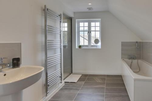 ein Badezimmer mit einem Waschbecken, einer Badewanne und einer Dusche in der Unterkunft Towerview Apartments Braintree in Braintree