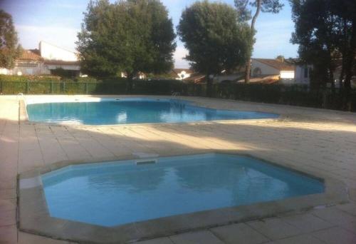 een groot blauw zwembad in een tuin bij Villa "les jardins de saint palais sur mer" in Saint-Palais-sur-Mer