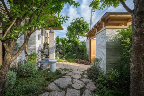 a garden with a stone path leading to a house at SHAN Villas Sukhumvit in Bangkok