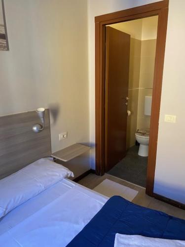 ミラノにあるホテル ガッラのベッドルーム1室(ベッド1台付)、バスルーム(トイレ付)