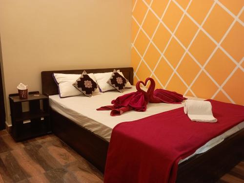 蒂魯吉拉帕利的住宿－Sri Arangan Kudil Rooms，一间卧室配有一张床铺,床上铺有红色毯子