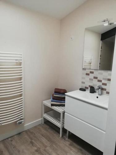 une salle de bain blanche avec un lavabo et un miroir dans l'établissement Gîte romantique avec SPA cœur à corps 44, à La Plaine-sur-Mer