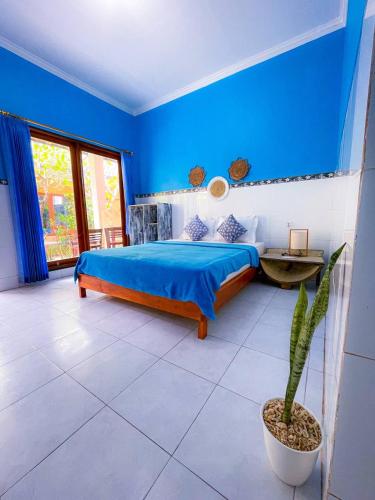 a blue bedroom with a bed and a potted plant at Pandan Wangi in Nusa Lembongan