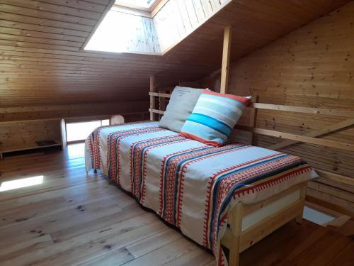 a bed in a log cabin with a skylight at Maison entière avec petite cour intérieure. in Monthureux-sur-Saône