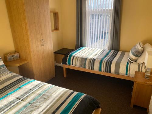 a small room with two beds and a window at Station House in Merthyr Tydfil