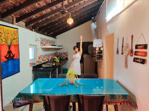 Una mujer parada en una mesa en una habitación en Casa Brooklyn Portuguese Heritage, en Saligao