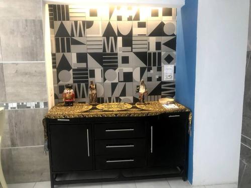 a bathroom with a black counter and a wall at Habitación Irving confortable con baño privado in Mexico City