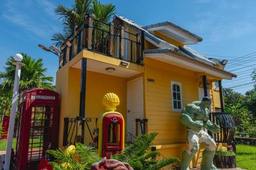 a house with a superhero statue in front of it at Apinya Resort Bangsarey in Ban Tao Than