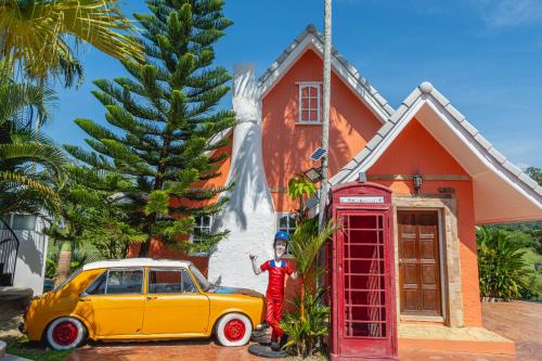 a person standing next to a phone booth and a car at Apinya Resort Bangsarey in Ban Tao Than