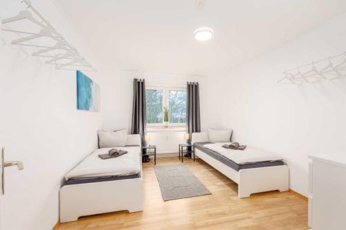 a white room with two beds and a window at Modern Apartments near Bottrop in Gladbeck