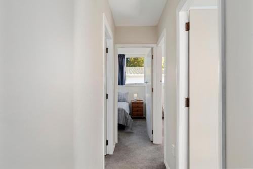 a hallway with white walls and a bed in a room at The Orchard House - Turangi Holiday Home in Turangi