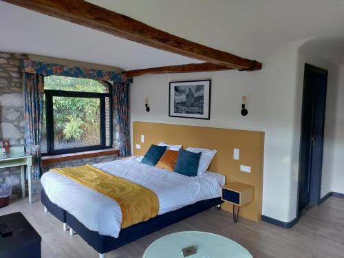 een slaapkamer met een groot bed in een kamer bij Hotel Le Moulin Des Ramiers in Crupet