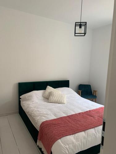 a bedroom with a bed with a red and white blanket at Apartament Warszawska 33 in Mrągowo