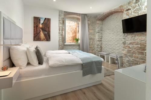 - une chambre blanche avec un lit et une télévision dans l'établissement Bernardi Rooms, à Split