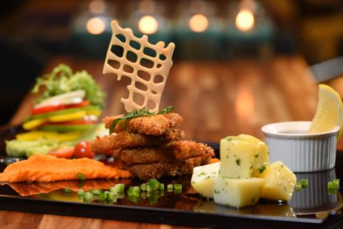 a plate of food with meat and vegetables on a table at Holiday Inn Cikarang Jababeka by IHG in Cikarang
