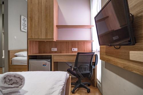 een slaapkamer met een bureau met een stoel en een televisie bij 3J Living in Binong