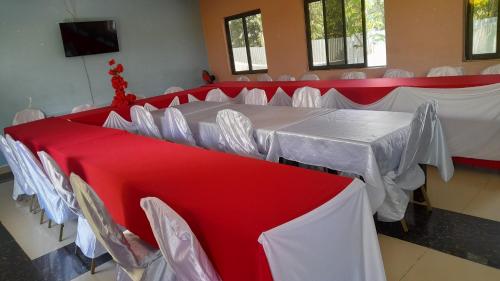 Habitación con mesas y sillas rojas y blancas en HILLVIEW ECO-TOURISM RESORT, en Bungoma