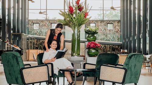 a woman is sitting in a chair with a laptop at Royal Green Wellness Resort in Moka