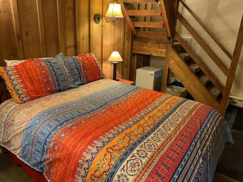 a bed with a colorful comforter in a room at The Viking Lodge - Downtown Winter Park Colorado in Winter Park