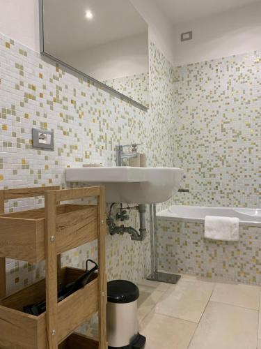 uma casa de banho com um lavatório e uma banheira em Ca' Rosa Charming Suite em Veneza