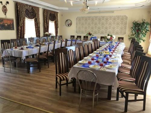 a long dining room with long tables and chairs at Motel Kochlice in Kochlice