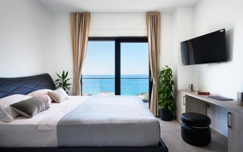 a bedroom with a bed with a view of the ocean at Villa Infinity View in Primošten