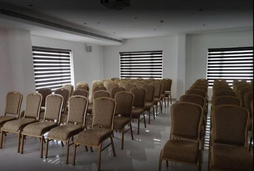 uma fila de cadeiras num quarto com janelas em Bhagavath Residency em Pathanāmthitta