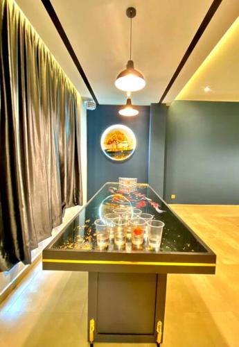 a glass table with food on it in a room at Kuala Selangor Modern Homestay with Pool 20pax in Kuala Selangor