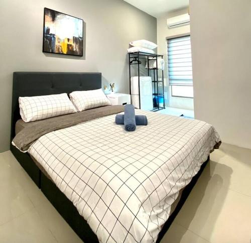a bedroom with a large bed with a white blanket at Kuala Selangor Modern Homestay with Pool 20pax in Kuala Selangor