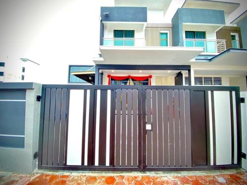 a house with a gate in front of it at Kuala Selangor Modern Homestay with Pool 20pax in Kuala Selangor