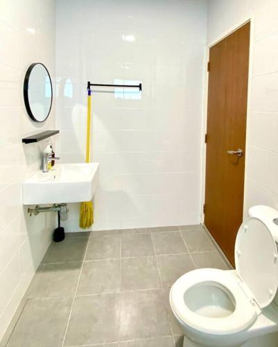 a white bathroom with a toilet and a sink at Kuala Selangor Modern Homestay with Pool 20pax in Kuala Selangor