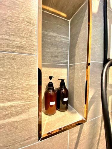two bottles of soap are sitting on a shelf in a bathroom at Kuala Selangor Modern Homestay with Pool 20pax in Kuala Selangor