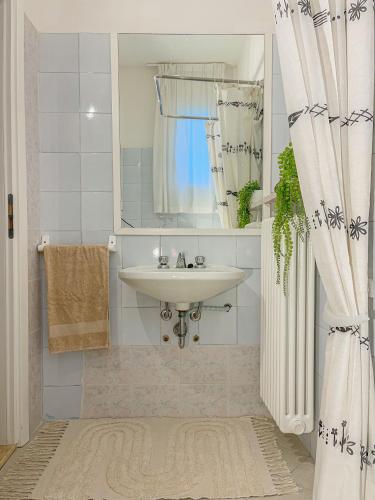 a bathroom with a sink and a mirror at Americana Beach House in Rimini