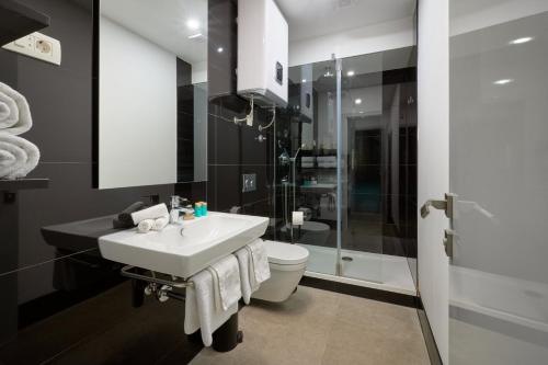 La salle de bains est pourvue d'un lavabo, de toilettes et d'une douche. dans l'établissement Bernardi Rooms, à Split
