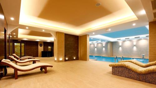a lobby with couches and a pool in a building at Aleksandar Palace Hotel Congress Center & SPA in Skopje