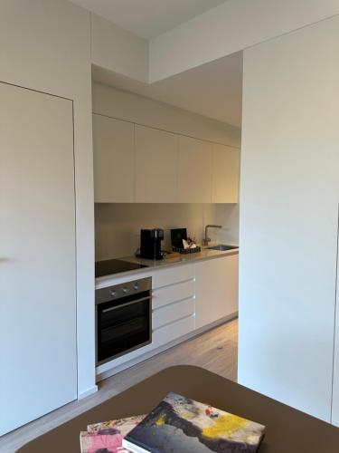 a kitchen with white cabinets and a table at Riva 14 in Lugano
