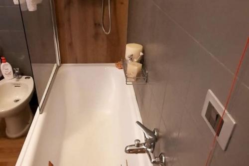 een badkamer met een wit bad en een wastafel bij Ai piedi del Centro Storico in Castiglione del Lago
